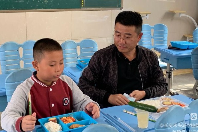 图为家长和孩子同吃午餐