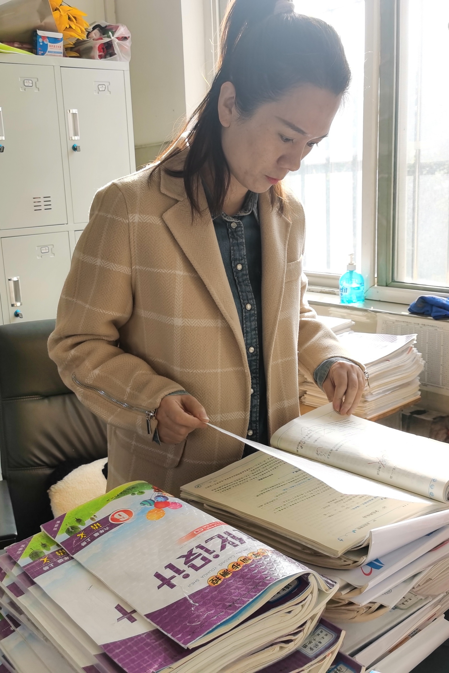 图为副校长田源检查毕业年级作业批阅情况