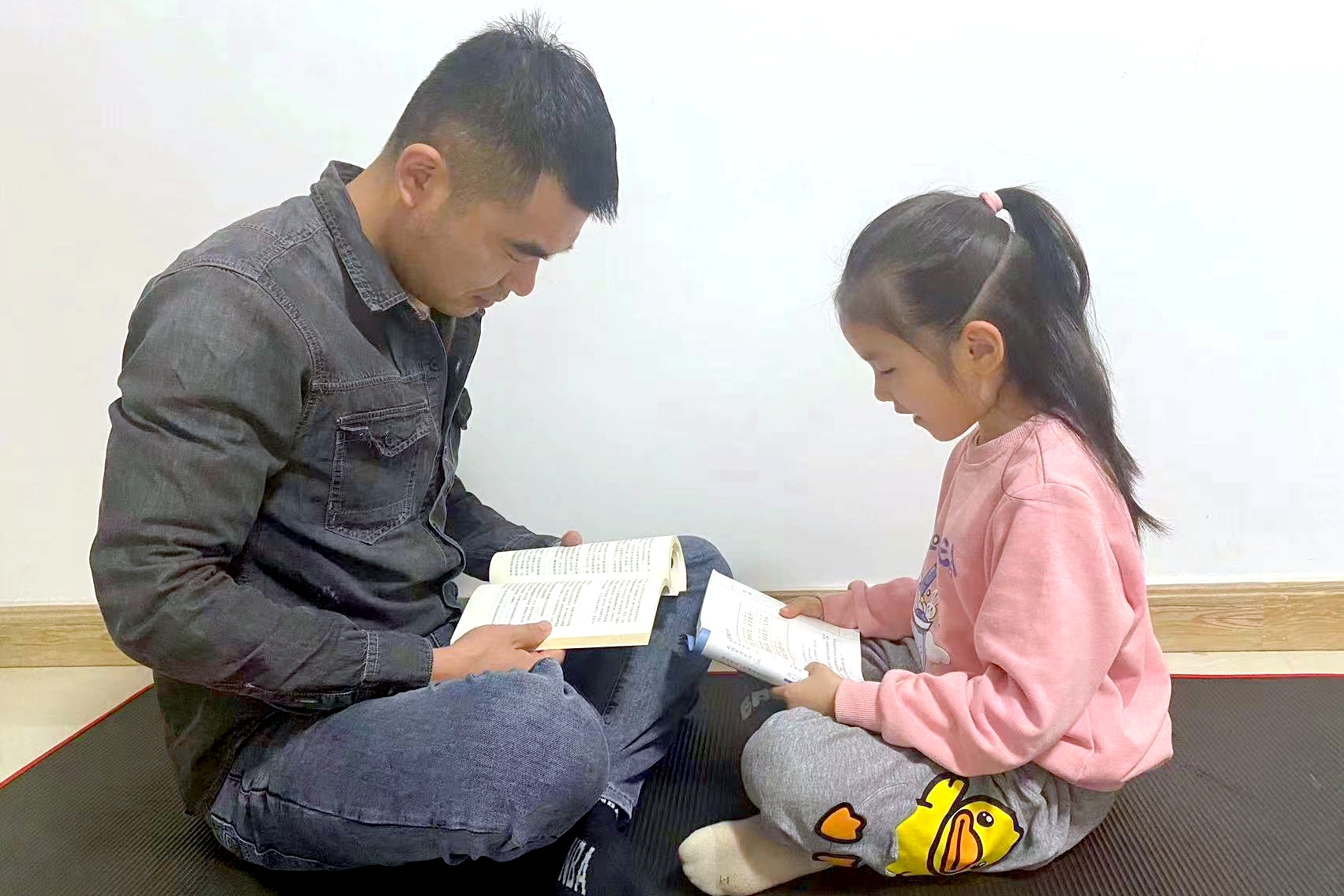 图为学生与家长亲子阅读