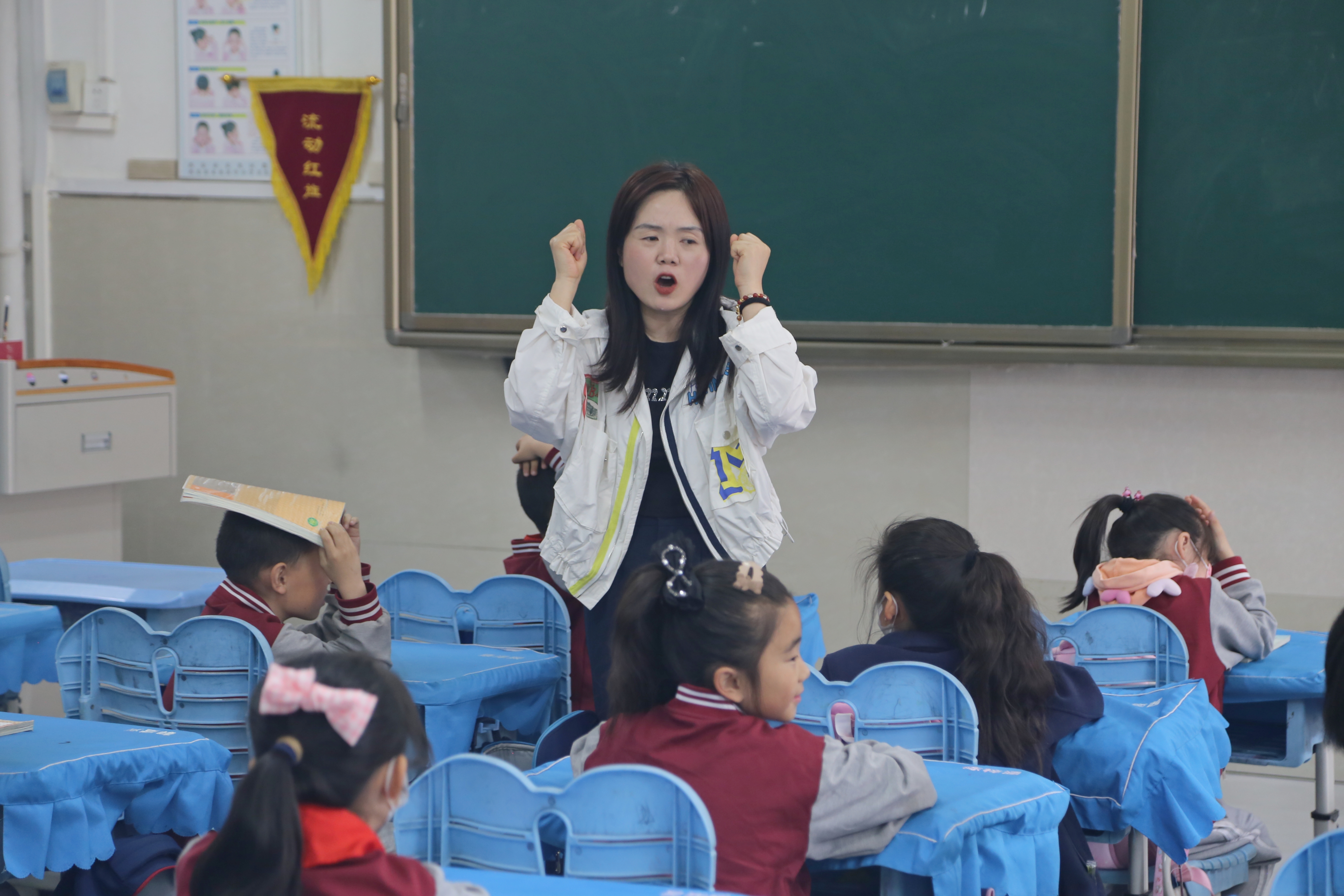 图为教师对二年级小学生进行防震教育