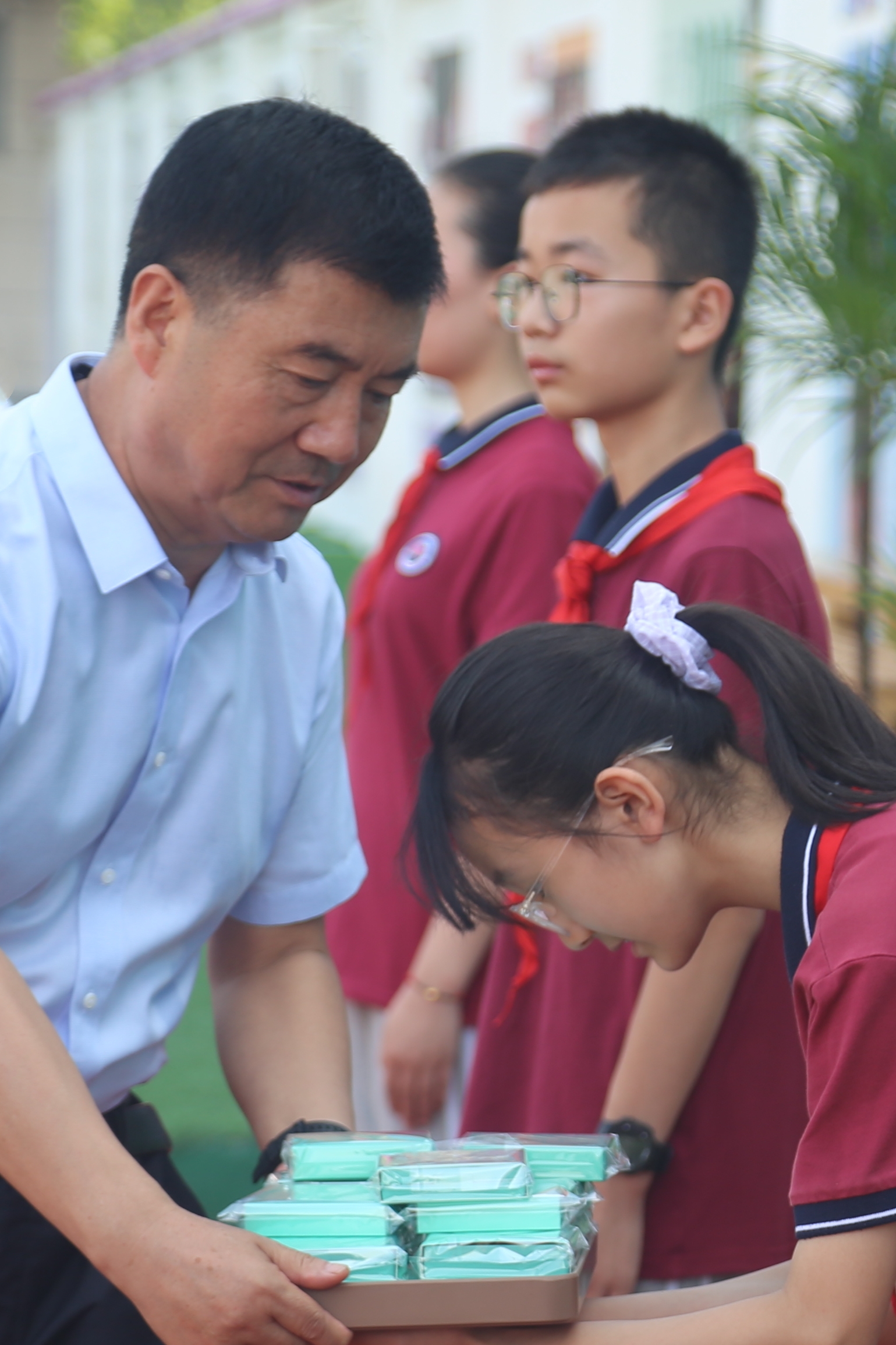窦兴武为班级代表颁发了印有学校校徽的纪念品