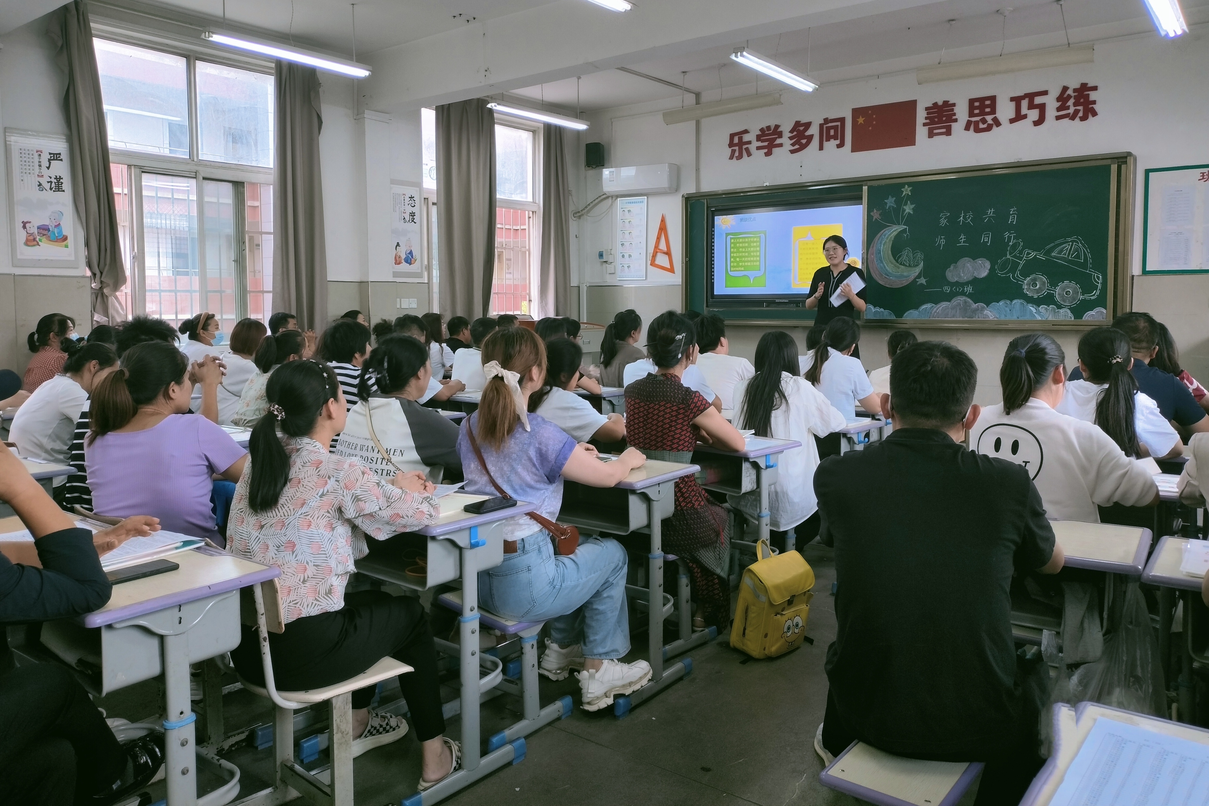图为班主任与家长反馈交流